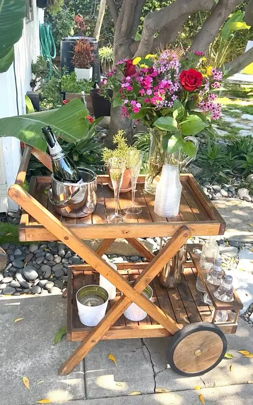 : DIY backyard bar cart with flowers, champagne, and summer drinks.
