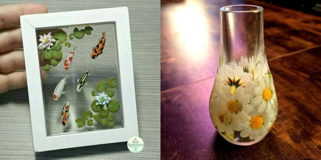 “Collage of two resin artworks: one is a framed koi pond with colorful fish and green lily pads, and the other is a clear resin vase embedded with white daisies and yellow centers.”