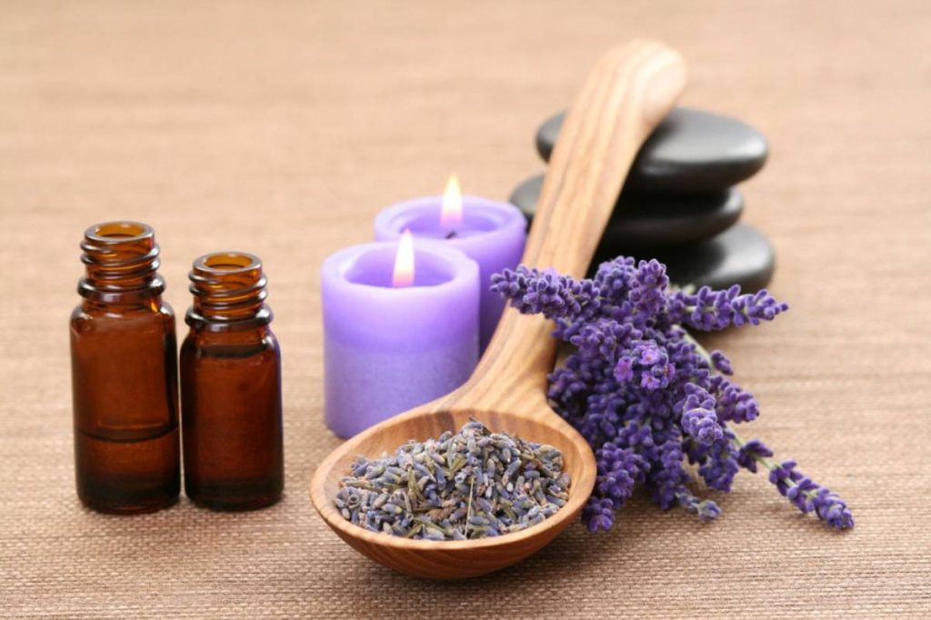 Lavender essential oil with flowers and candles for calming the nervous system.