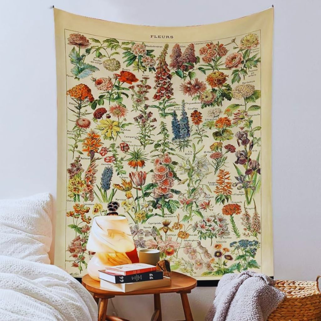Medieval-style tapestry with floral and heraldic designs hanging on a wall in a cozy vintage room.