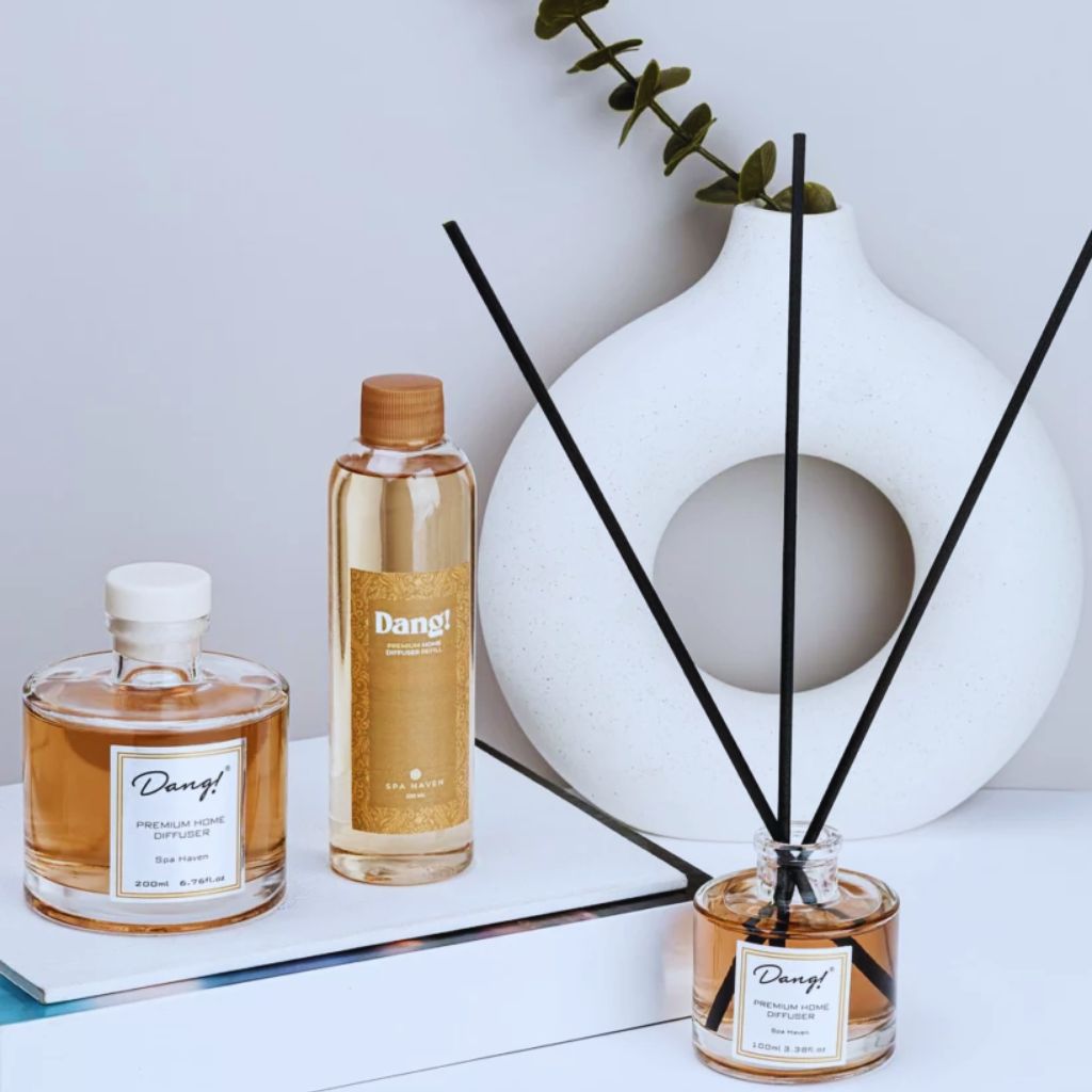 Essential oil diffuser bottle with wooden reeds and custom label.