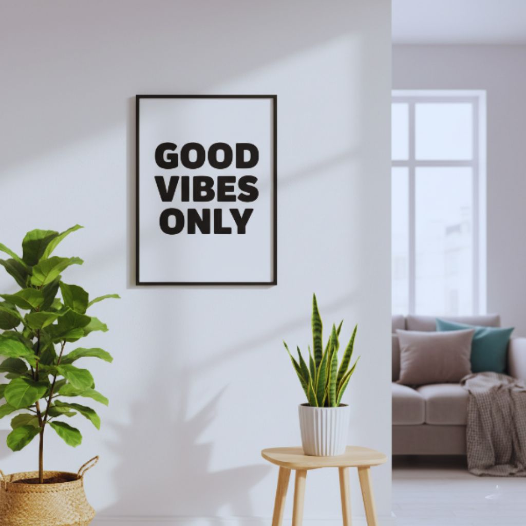 Black typography wall art with “Good Vibes Only” displayed in a modern living room.