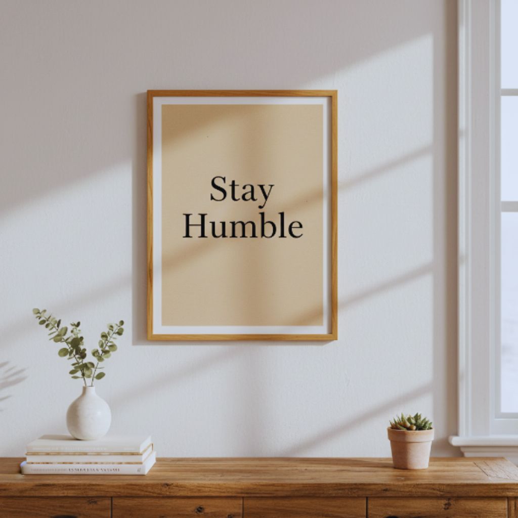 Neutral minimalist poster with “Stay Humble” in black serif font framed in wood.