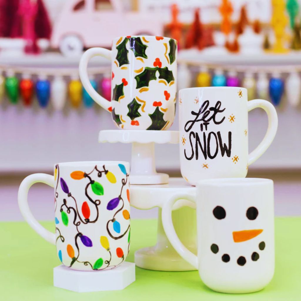 Hand-painted ceramic mugs with colorful doodles and names.