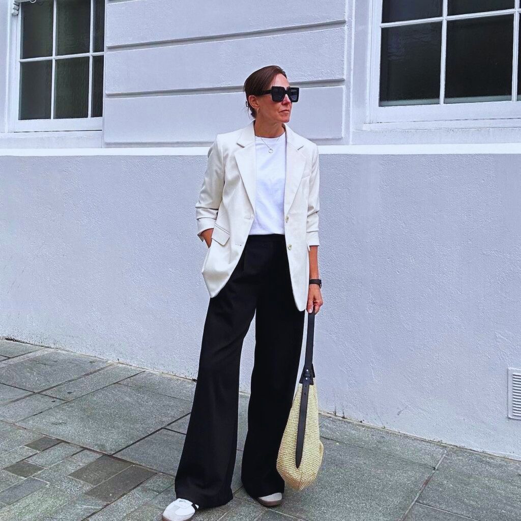 Professional woman in tailored wide-leg trousers, blazer, and shirt for a polished business look.