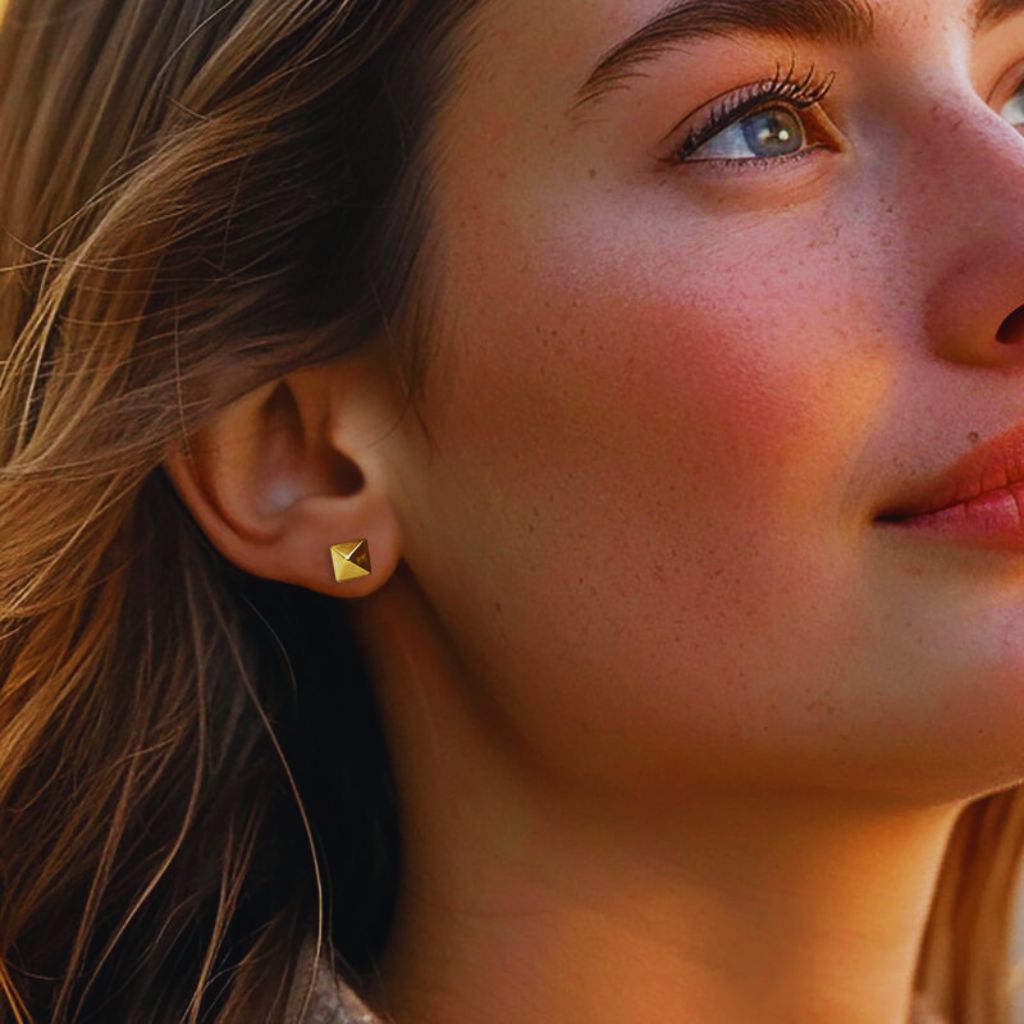 Close-up of minimalist gold stud earrings in geometric shape for a modern everyday look.