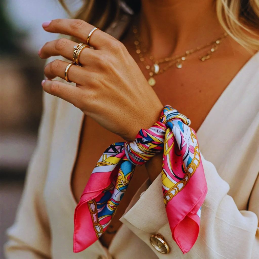 “Close-up of a woman’s wrist wrapped with a silk scarf, styled as a chic accessory.”