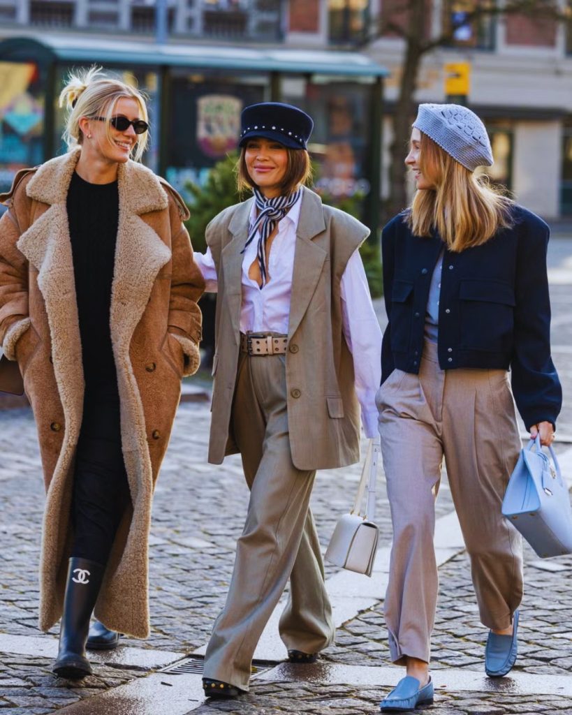 Minimalist capsule wardrobe with neutral clothing pieces like blazer, white shirt, and jeans.