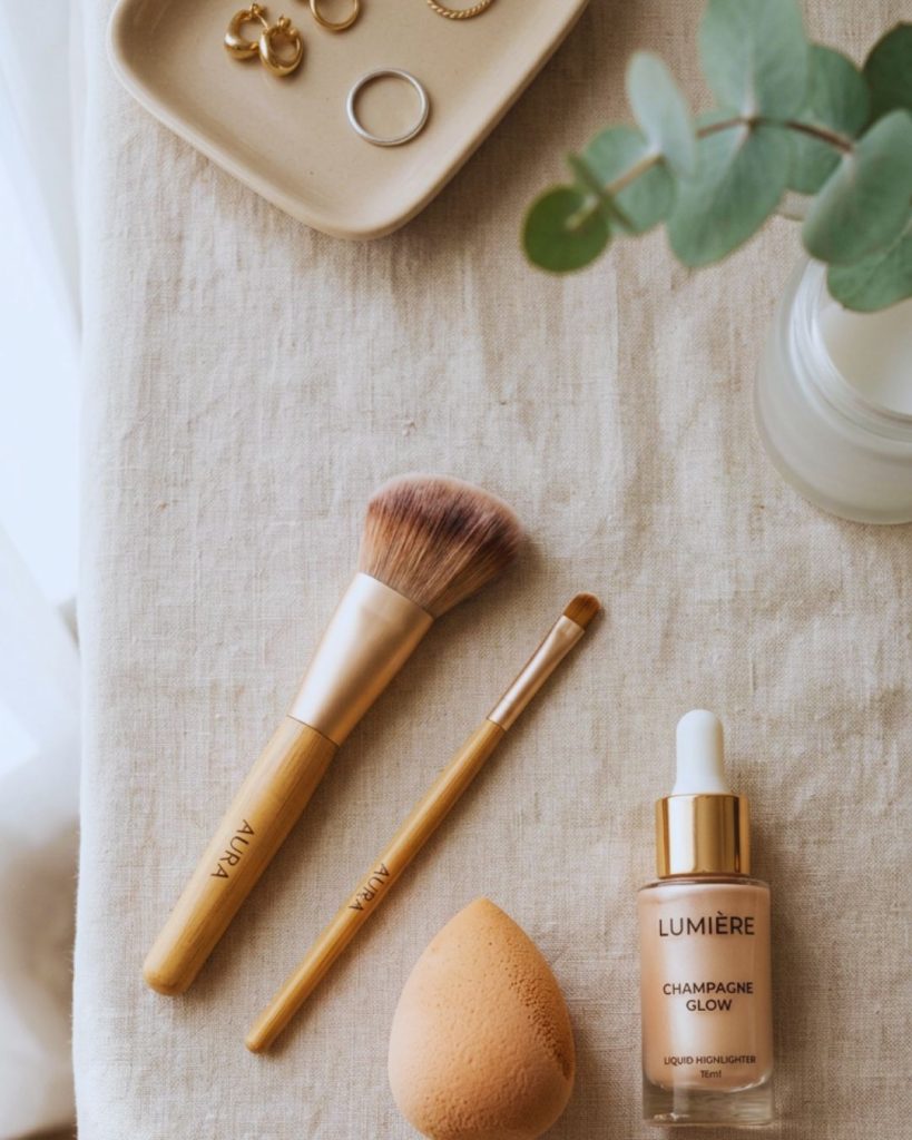 Makeup tools including angled brush, detail brush, beauty sponge, and liquid highlighter used for a lifted face makeup routine.