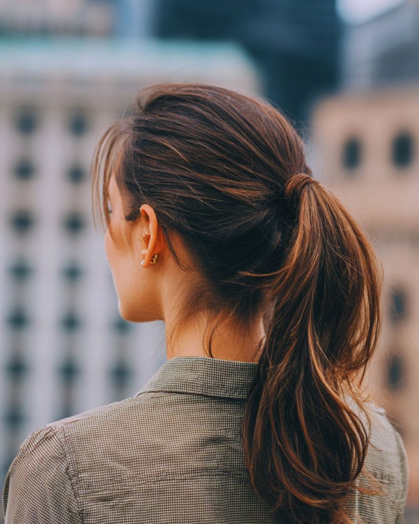 Woman with natural messy bun and soft waves showing effortless French girl hairstyle.
